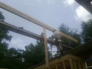 Carpenter setting a ridge beam over a new addition frame — Ice Dam Removal by Roofing Brothers in Hollis